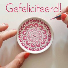 two hands holding a bowl with pink designs on it and the words gefelicitered written in large letters