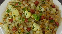 a white plate topped with corn, potatoes and garnished with cilantro