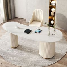 a white table sitting on top of a wooden floor next to a chair and mirror