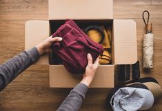 a person opening up a box with clothing inside