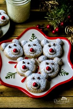 christmas cookies decorated with teddy bears on a red and white platter next to other holiday treats