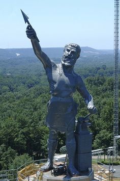 a statue of a man holding a knife in his right hand and pointing to the sky