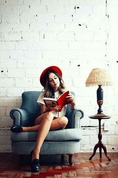 a woman sitting in a chair reading a book