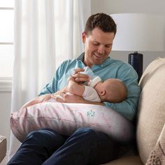 a man sitting on a couch holding a baby