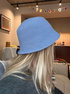 a woman with long blonde hair wearing a blue knitted hat in a living room