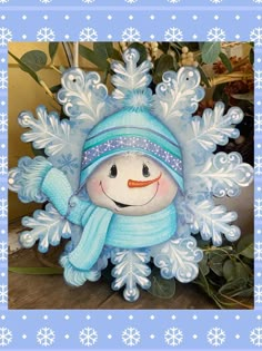 a snowman with a blue hat and scarf