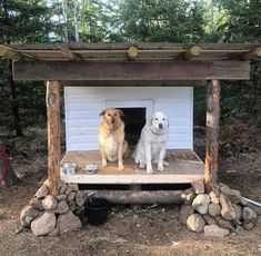 two dogs are sitting in the dog house made out of logs and wood, outside