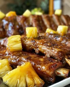 pineapple and pork chops on a plate with other food items in the background