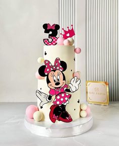 a three tiered cake with minnie mouse on it