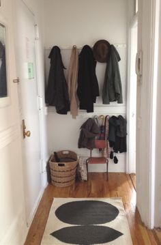 an entryway with coat racks and rugs on the floor