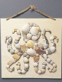 an art piece made out of seashells hanging on a wall