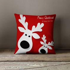 a red pillow with white reindeer faces on it