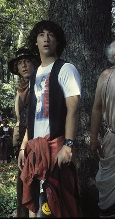 a group of men standing next to each other near a tree