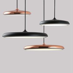 three black and copper pendant lights hanging from the ceiling, with one light turned on