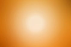 an orange and yellow background with the sun in the distance