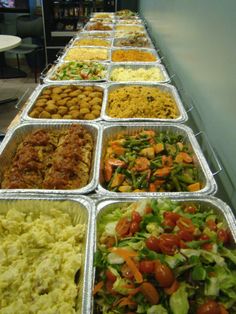 many trays of food are lined up on the table in front of each other