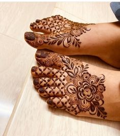 two feet with henna tattoos on them