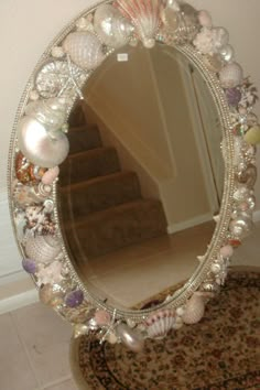 a mirror that is sitting on top of a table with shells and seashells around it