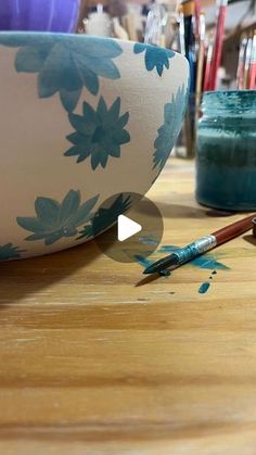 a wooden table topped with a bowl filled with paint