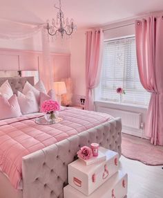 a bedroom decorated in pink and white with chandelier