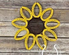 a yellow metal flower on a wooden surface