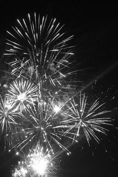 black and white photograph of fireworks in the night sky