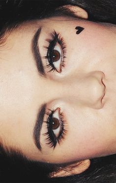 a close up of a woman's face with eyeliners and long lashes