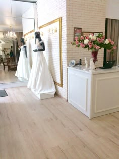 two mannequins dressed in white are on display at a bridal gown shop