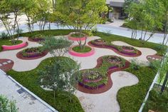 an aerial view of a garden in the middle of a yard with trees and bushes