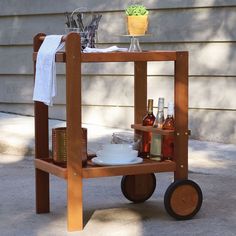 a wooden cart with drinks and bottles on it