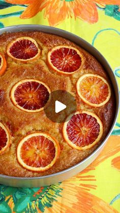 an orange upside down cake in a pan on a tablecloth with flowers and leaves