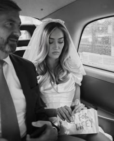 a bride and groom sitting in the back seat of a car on their wedding day