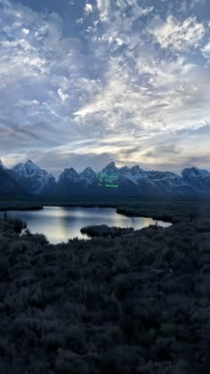 an airplane flying over a lake surrounded by mountains