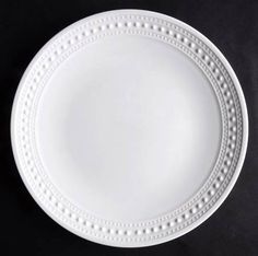 an empty white plate on a black background