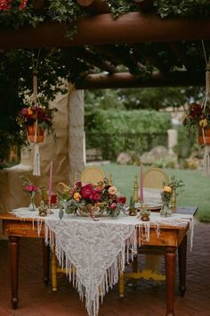 a table with flowers and candles on it in the middle of an outdoor patio area