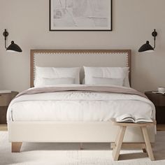 a white bed sitting in a bedroom next to two lamps