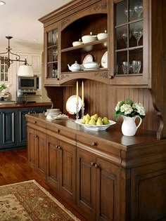 a kitchen with wooden cabinets and white dishes