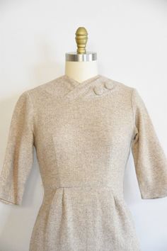 "Vintage 1950s wool dress. Oat colored wool. V high collar with decorative buttons, seamed bust, and long sleeves. Straight skirt with back metal zipper closure. Unlined. *item has not been dry cleaned State of garment | excellent. Measurements ✂--- Best fit | Small/ Medium Bust | up to 35\" Shoulders | 14\" Shoulder to waist | 15\"\" Sleeves | 15\" Waist | 26.5- snug 27\" Hips | up to 38\" Total length (shoulder to hem) | 39\" Tag | ★★Visit The Shop★★ http://www.etsy.com/shop/seaofvintage ➸ Fin Vintage Beige Dress For Winter, Vintage Beige Dresses For Winter, Vintage Beige Winter Dress, Fitted Wool Dress In Beige, Fitted Beige Wool Dress, Tea Party Bridal Shower, Peach Dress, Everyday Chic, Hip Ups