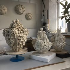 three white vases sitting on top of a table