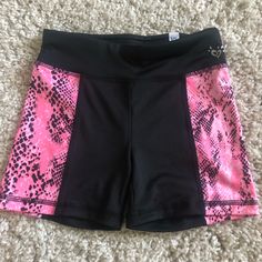 a pair of pink and black shorts laying on the floor