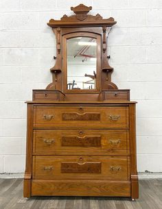 an old dresser with a mirror on top of it and wooden drawers underneath the drawer