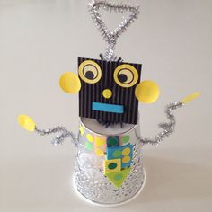 an origami robot made out of tinfoil and some sort of chain hanging from it's neck