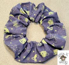 a purple scrunch with yellow stars and planets on it