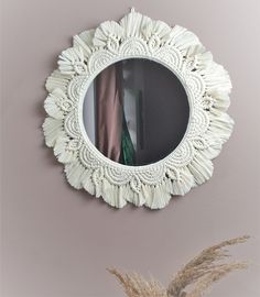 a mirror hanging on the wall above a plant