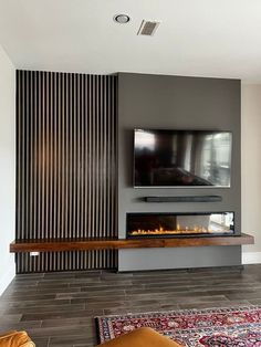 a living room with a fireplace and television on the wall in front of a flat screen tv