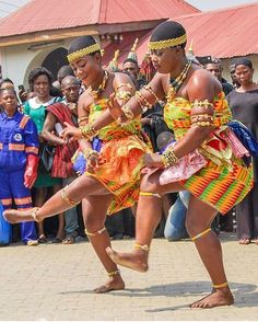 two women in colorful costumes dancing on the street