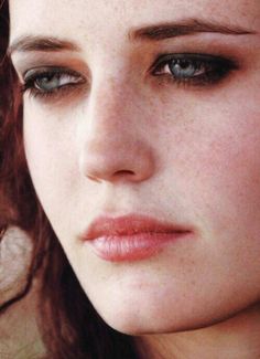 a close up photo of a woman with freckles on her face