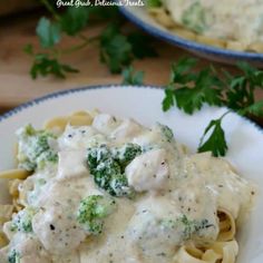 a white plate topped with pasta and broccoli covered in gravy next to parsley