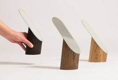 three pieces of wood with different shapes and sizes being held by a person's hand