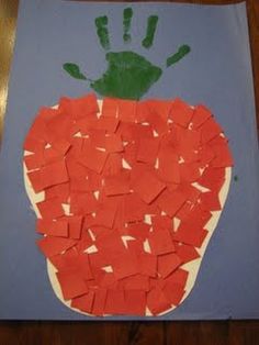 a handprint made out of orange pieces of paper on top of a blue board